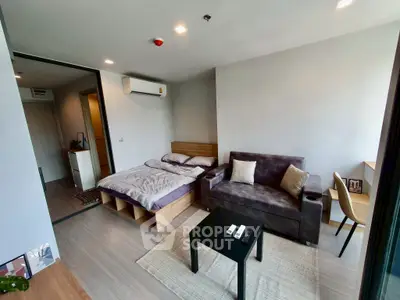 Modern studio apartment with cozy bed and stylish sofa in open layout.