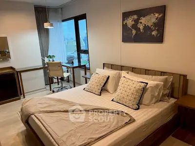 Modern bedroom with city view, stylish decor, and workspace, perfect for urban living.