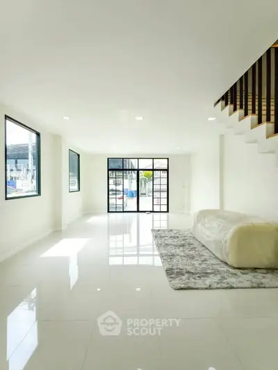 Spacious modern living room with large windows and sleek white flooring