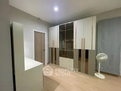 Spacious bedroom with modern wardrobe and wooden flooring