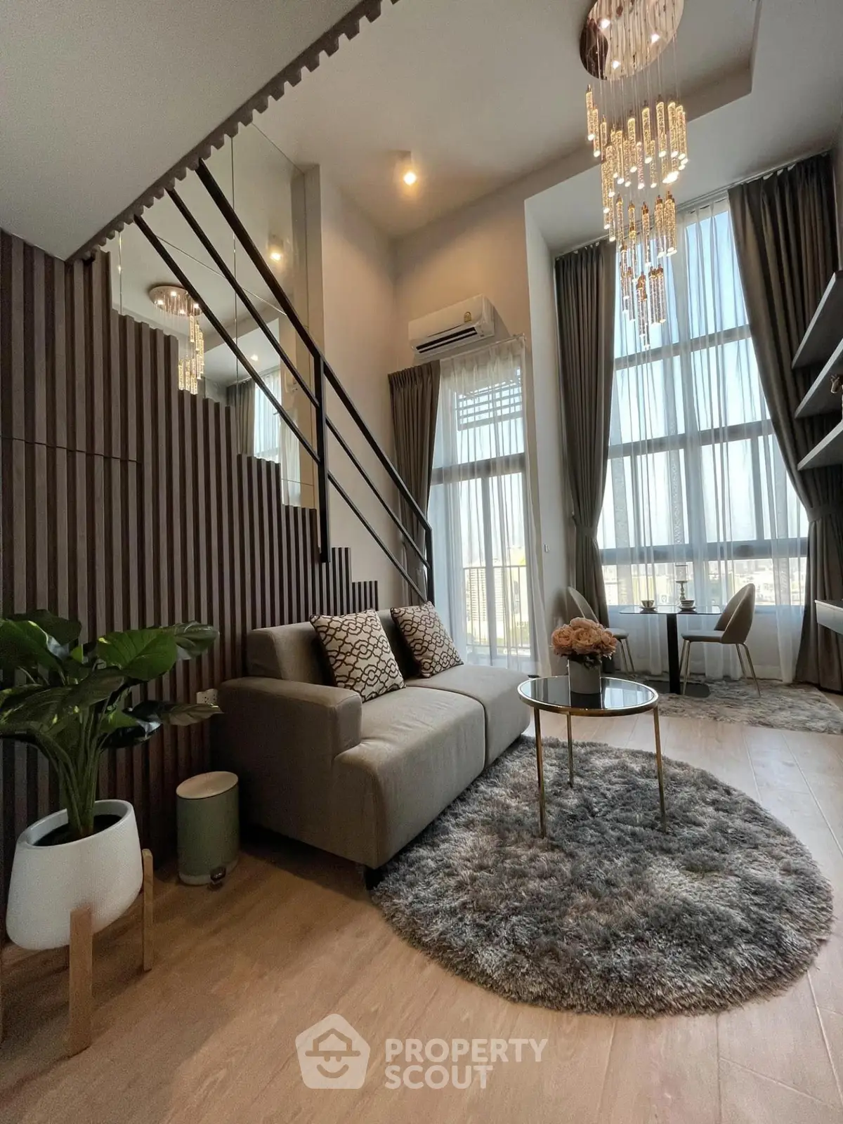 Luxurious modern living room with high ceilings, elegant chandelier, and stylish decor in a spacious apartment.