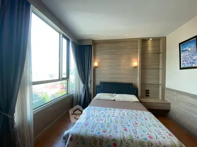 Cozy bedroom with large window and elegant decor in modern apartment