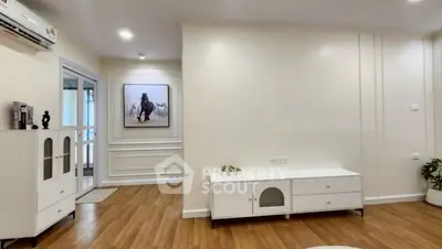 Modern living room with wooden flooring and elegant white furniture