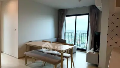 Modern living room with dining area and large window offering stunning city views.