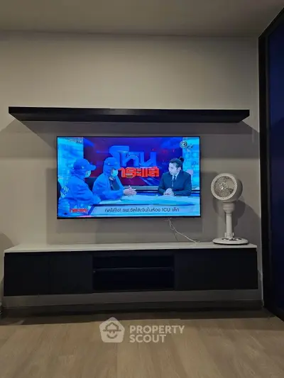 Modern living room with wall-mounted TV and sleek black and white furniture