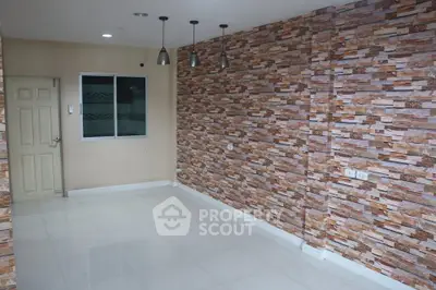 Spacious room with modern stone accent wall and sleek lighting fixtures.