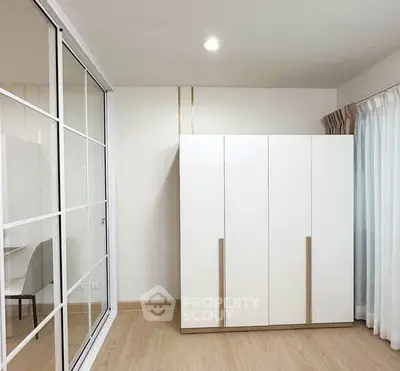 Modern minimalist bedroom with sleek wardrobe and sliding glass doors