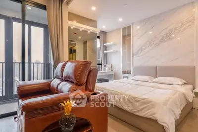 Luxurious bedroom with leather recliner and city view balcony