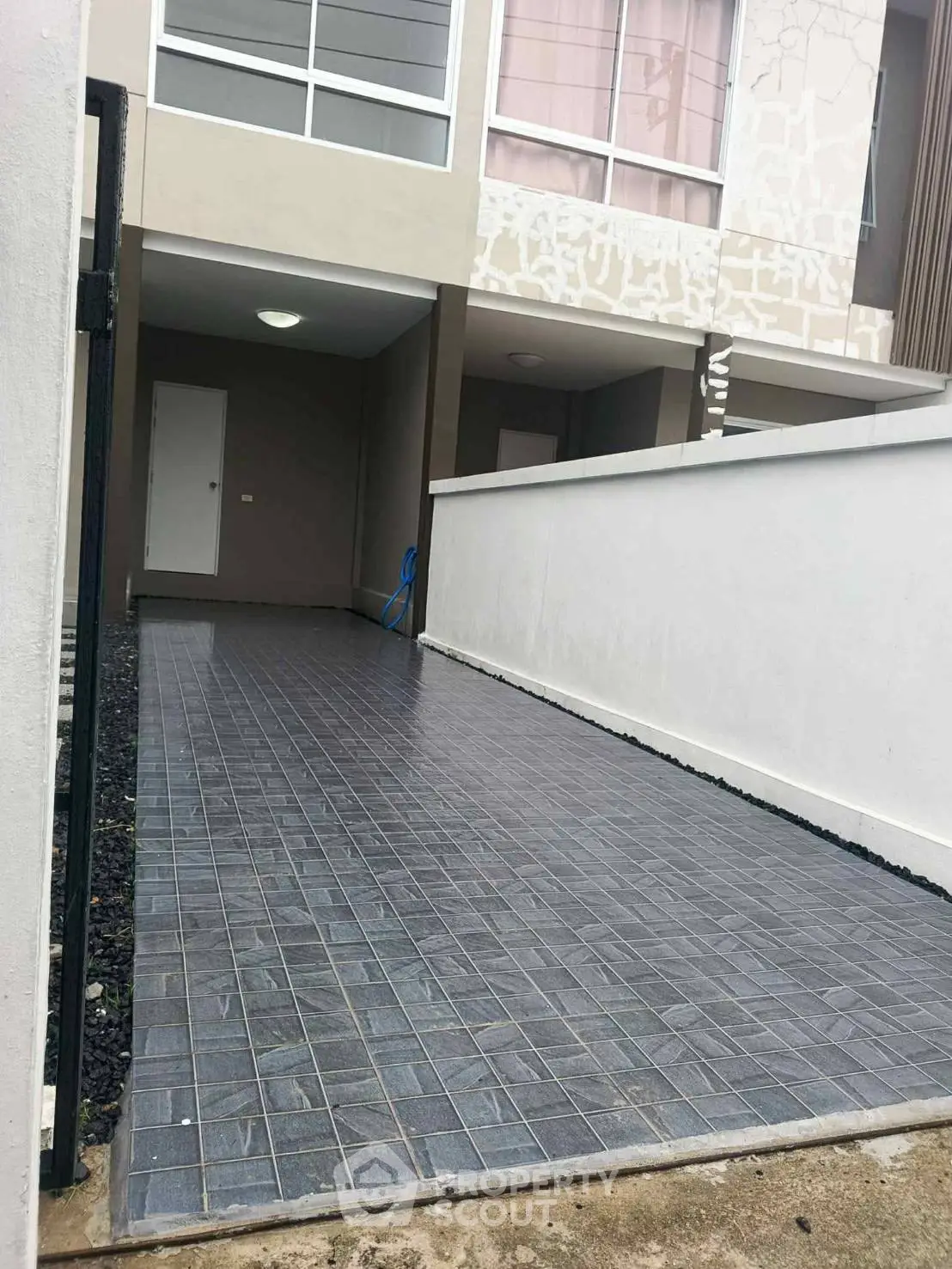 Modern townhouse entrance with tiled pathway and minimalist design