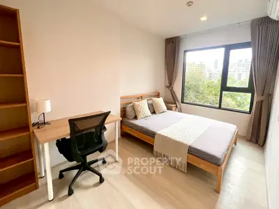 Modern bedroom with city view, featuring a cozy bed and workspace.