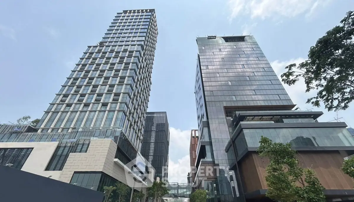 Modern high-rise buildings with sleek glass facades and lush greenery.
