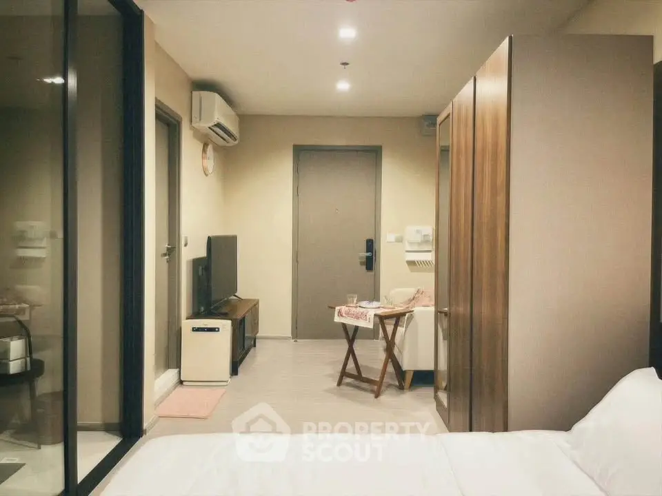 Modern studio apartment with sleek design and cozy ambiance, featuring a compact living area and stylish furnishings.