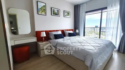 Modern bedroom with stylish decor and balcony view in a high-rise apartment.