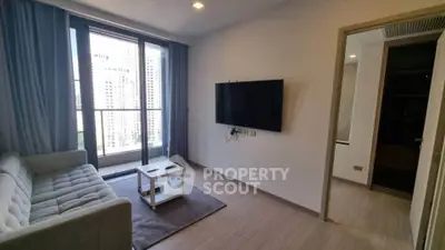 Modern living room with large window and wall-mounted TV in a stylish apartment.
