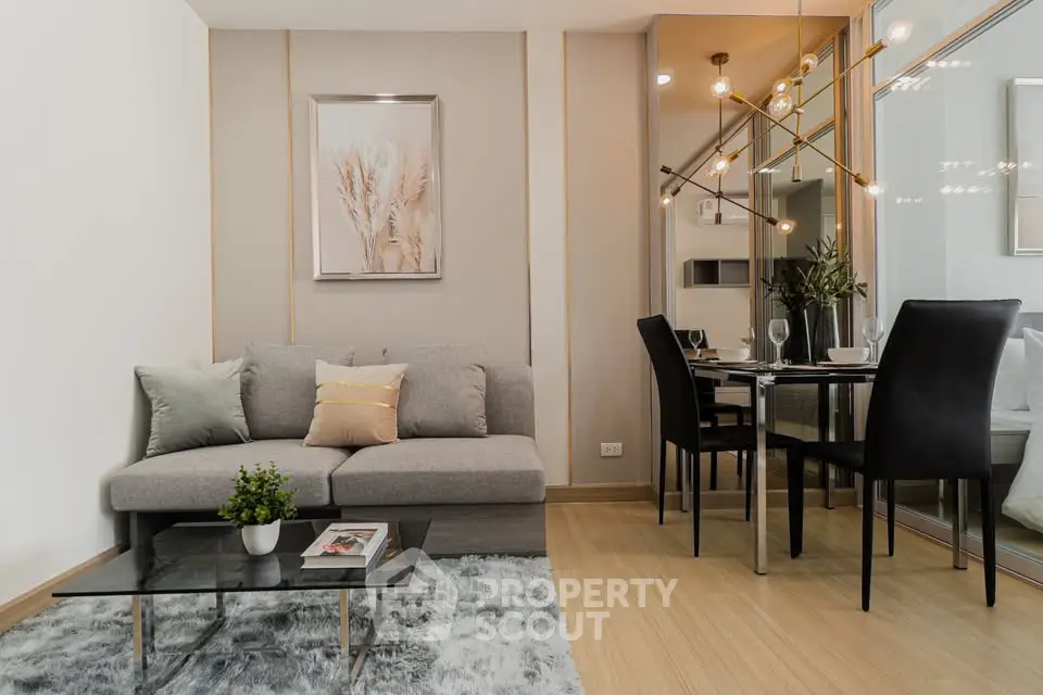 Modern living room with stylish decor and dining area, featuring elegant lighting and cozy seating.