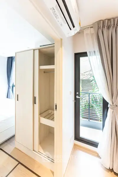 Bright bedroom with balcony access and modern wardrobe in a stylish apartment.