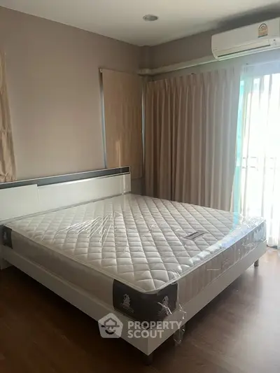 Spacious bedroom with large window and modern air conditioning unit