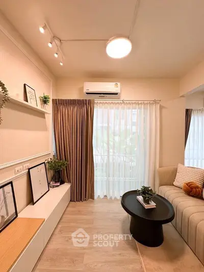 Modern living room with elegant decor, cozy seating, and natural light through large windows.