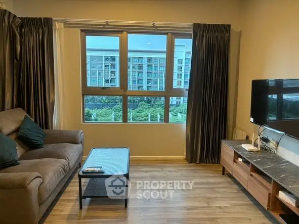 Modern living room with large window and stylish furniture in urban apartment.