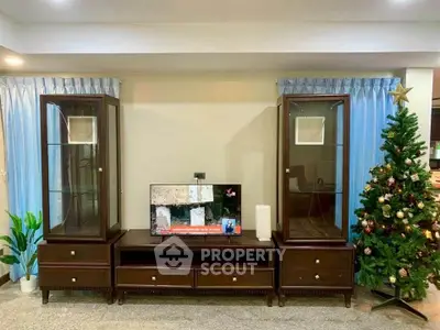 Elegant living room with festive decor and modern entertainment center.