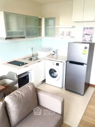Modern kitchen with washing machine and fridge in cozy apartment