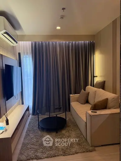 Cozy living room with modern decor, featuring a comfortable sofa, flat-screen TV, and elegant curtains.