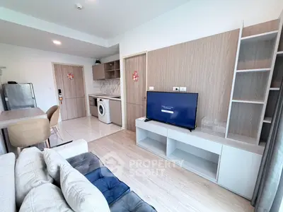 Modern living room with open kitchen, featuring sleek furniture and built-in appliances for stylish urban living.