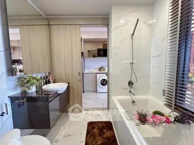 Luxurious bathroom with marble tiles, bathtub, and modern fixtures in a stylish home interior.