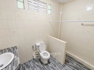 Spacious bathroom with modern tiling and open shower design