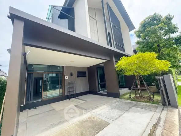 Modern two-story house with spacious driveway and lush greenery