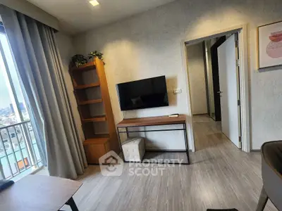 Modern living room with wall-mounted TV and city view, featuring stylish decor and natural light.