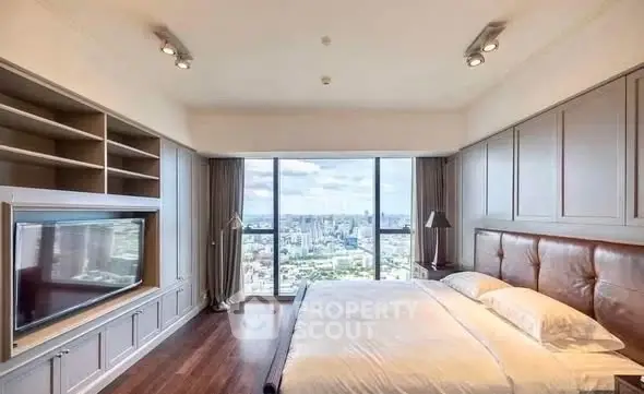 Luxurious bedroom with panoramic city view and elegant built-in shelving.