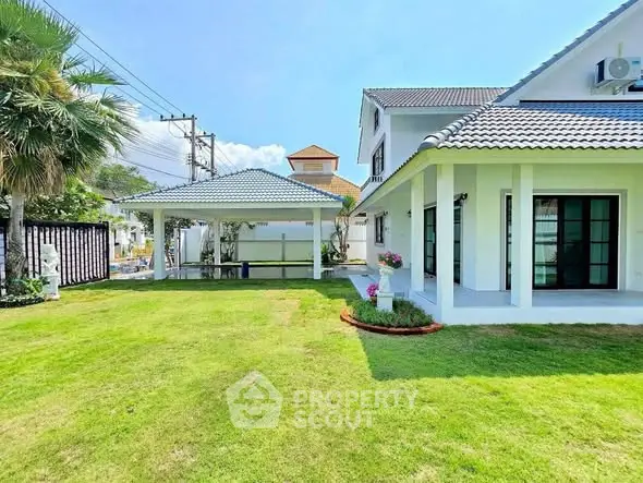 Charming suburban home with lush green lawn and spacious outdoor patio, perfect for family gatherings.