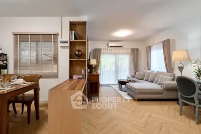 Spacious living room with elegant decor and natural light, featuring a cozy dining area and modern furnishings.
