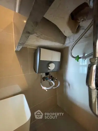 Compact bathroom with modern water heater and sleek fixtures.