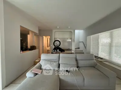 Spacious modern living room with stylish gray sectional sofa and open layout design.
