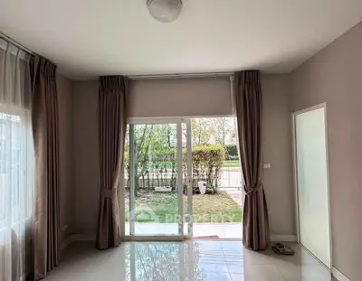 Spacious living room with large windows and garden view, perfect for natural light lovers.
