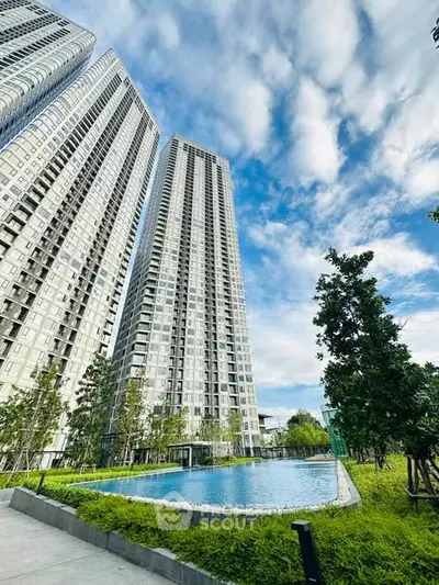 Stunning high-rise apartment buildings with lush greenery and a serene pool view.