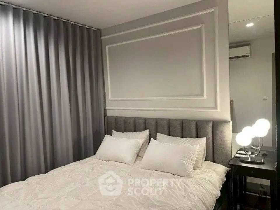 Elegant bedroom with plush headboard and modern lighting