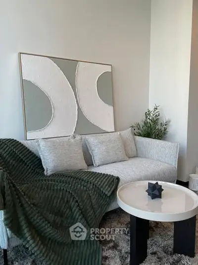 Stylish modern living room with cozy sofa and abstract art