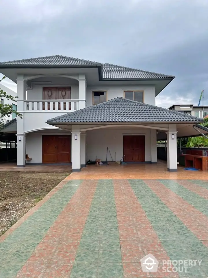 Spacious two-story house with tiled driveway and modern roof design