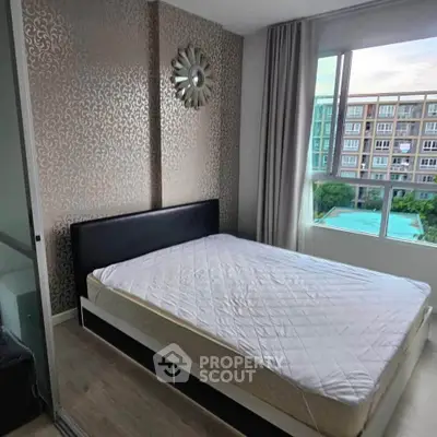 Modern bedroom with stylish wallpaper and large window overlooking pool and garden view.
