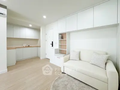 Modern living room with sleek white cabinetry and cozy sofa