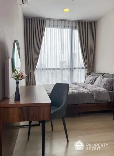 Modern bedroom with elegant decor and city view, featuring a stylish desk and comfortable bed.