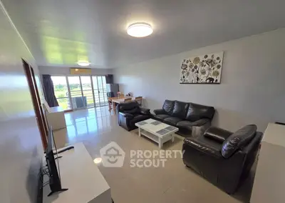 Spacious living room with modern furniture and large windows offering scenic views.