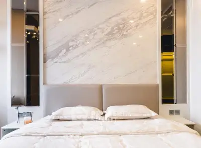 Luxurious bedroom with elegant marble accent wall and plush bedding