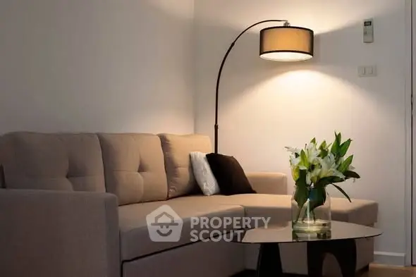 Cozy living room with modern sofa and elegant floor lamp, perfect for relaxation.