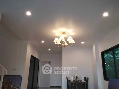 Modern dining area with elegant chandelier and natural light, perfect for family gatherings.
