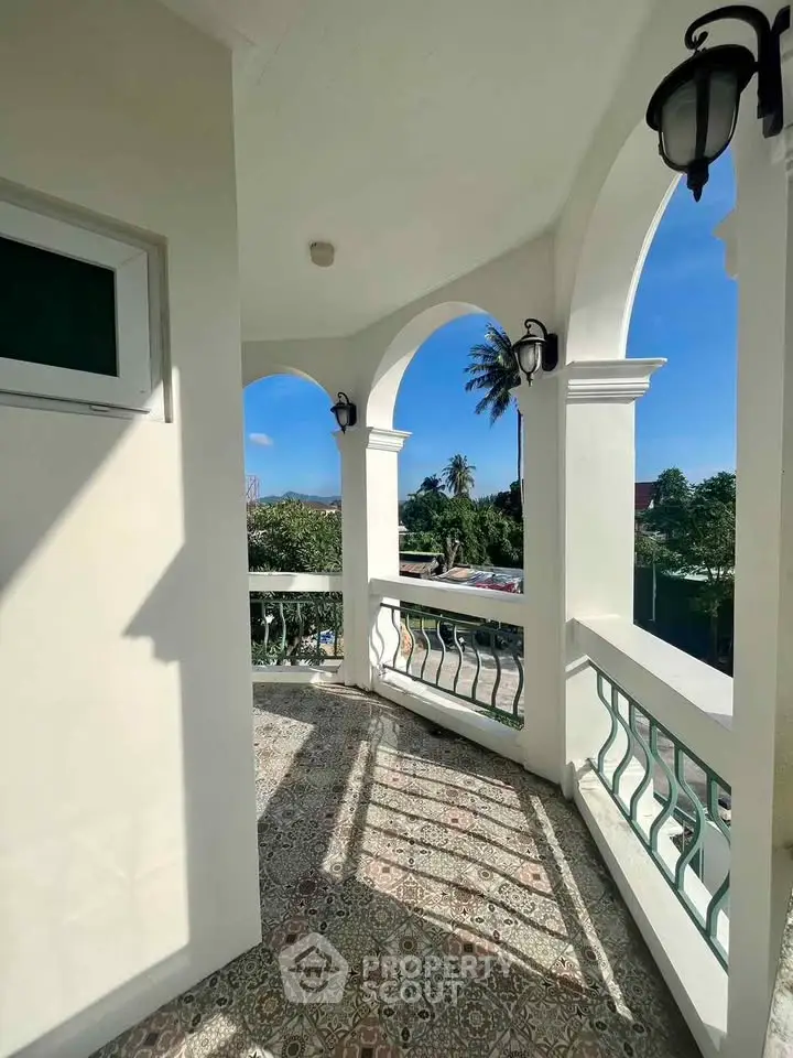 Charming balcony with elegant arches and scenic view, perfect for relaxation and enjoying the outdoors.
