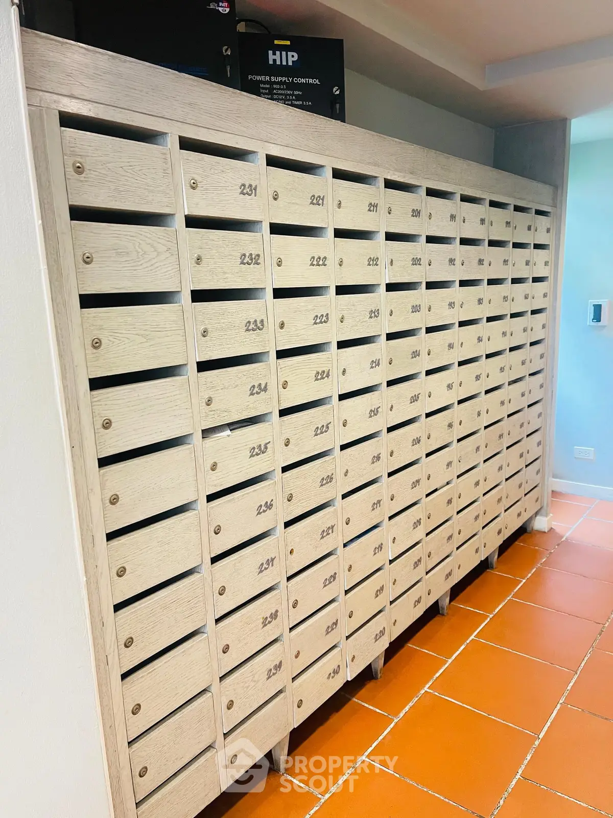 Modern apartment building mailboxes with numbered slots in a bright hallway.